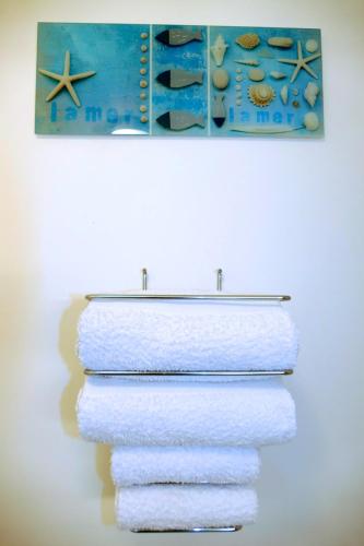 - un ensemble de serviettes sur un porte-serviettes avec un tableau dans l'établissement Studios Nice French Riviera, à Nice