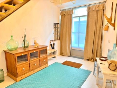 a living room with a wooden cabinet and a blue rug at Can PONÇ PARRA in Santanyi
