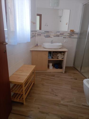 a bathroom with a sink and a wooden floor at La casa di Nonna Carta in Fordongianus