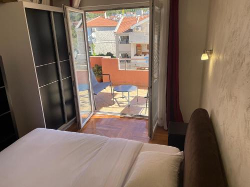 a bedroom with a bed and a view of a balcony at Teuta Apartment in Tivat in Župa