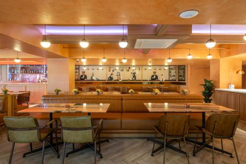 a restaurant with tables and chairs and a bar at Myhotel Cmyk@Ratchada in Bangkok