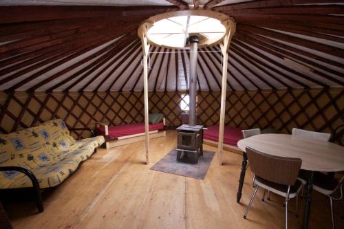 a room with a table and a stove in a yurt at Aux Berges du lac Castor in Saint-Paulin