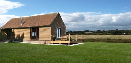 uma pequena casa num campo com relva em Knelle Dower Studio em Northiam