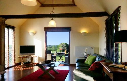 a living room with a couch and a large window at Knelle Dower Studio in Northiam