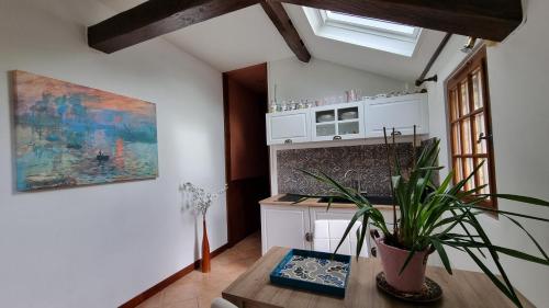 a kitchen with a table and a potted plant at Les Maisons de Mélody in Houlbec-Cocherel