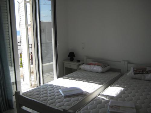 a bedroom with two twin beds and a window at Varmy in Ierápetra
