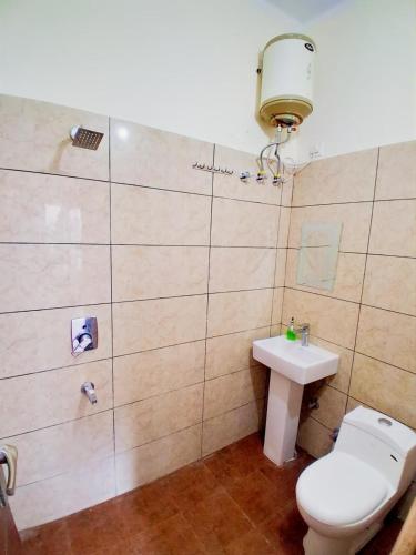 a bathroom with a toilet and a sink at WoodsPicker in Rishīkesh