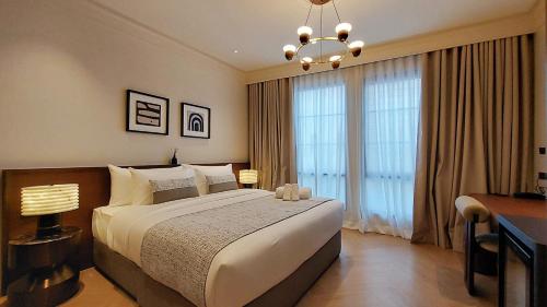 a bedroom with a large bed and a chandelier at Marwin Monique Hotel in Bangkok