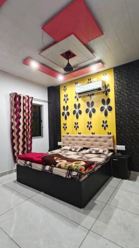 a bed in a room with a yellow wall at MMB Hotel in Bikaner