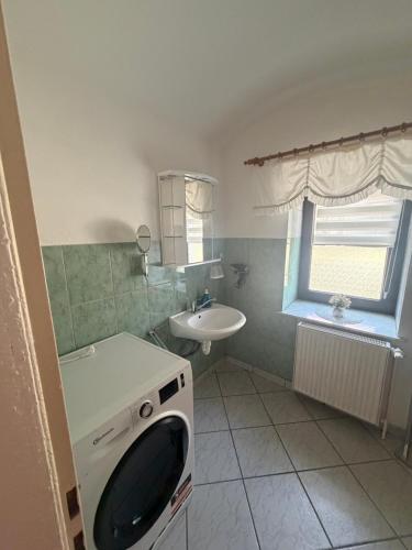 a bathroom with a washing machine and a sink at Ferienwohnung Fam.Stecher in Malschwitz