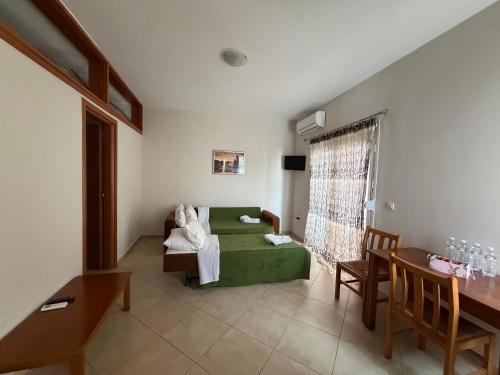 a living room with a green bed and a table at Villa Alexandra in Agia Marina Aegina