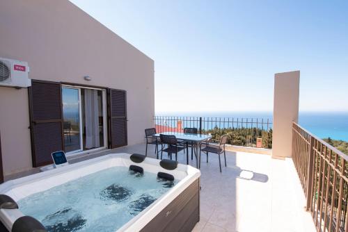 a hot tub on the balcony of a house at Scorpina Horizon Villa in Kalamitsi