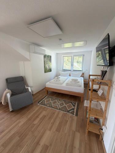 a room with a bed and a chair in it at Im Wald in Gleiszellen-Gleishorbach