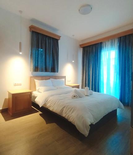 a bedroom with a large white bed with blue curtains at Metsovo apartment in Metsovo