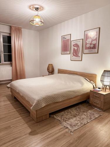 a bedroom with a bed and a table and a lamp at AURA House in Krępa