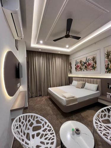 a bedroom with a bed and two tables and chairs at Hotel Neelkanth Prime Retreat, Kekri in Kekri