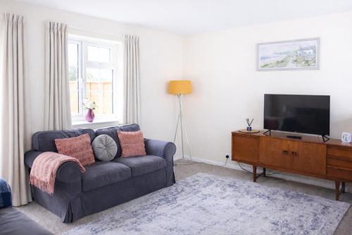 a living room with a couch and a flat screen tv at Oxford Cottage in Wheatley - Parking & Garden in Wheatley