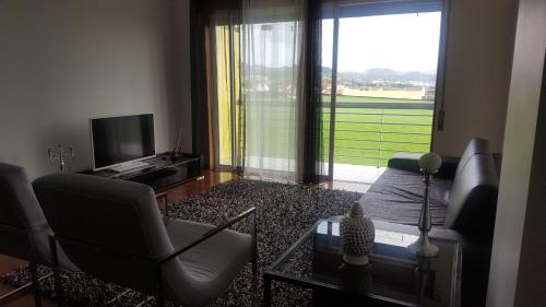 a living room with a couch and a tv at Apartamento Vista Deslumbrante in Ponta Delgada