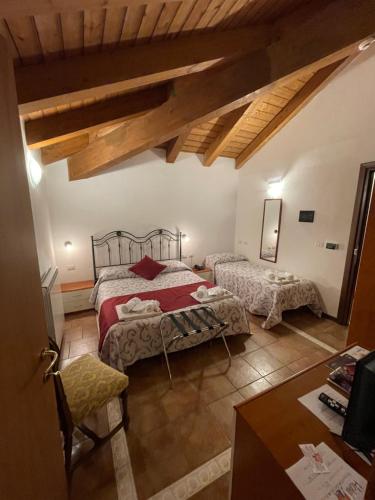 a bedroom with two beds in a room with wooden ceilings at Hotel Chalet du Soleil in Torgnon
