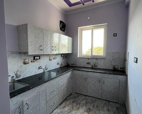 a white kitchen with a sink and a window at Bhadraj Valley Homestay in Dehradun