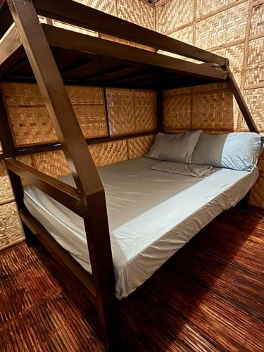 a bed in a room with a bunk bed at D Bamboo House in Mabini