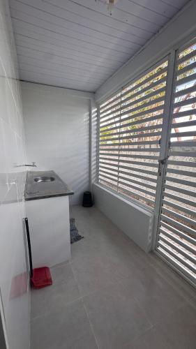an empty room with windows with blinds on them at Casa de veraneio jacuma in Conde