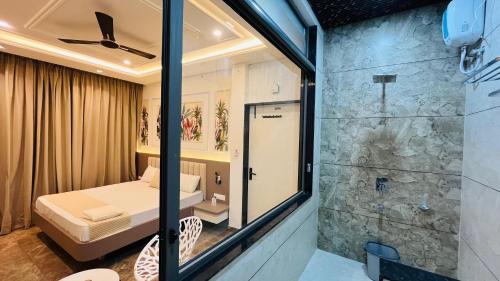 a room with a shower and a bed and a glass door at Hotel Neelkanth Prime Retreat, Kekri in Kekri