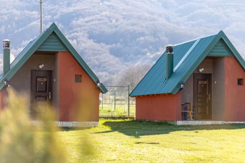 a small house with a blue roof in a field at Rest&peace homes in Mojkovac