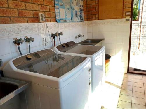 a kitchen with a sink and two sinks at Reef Villa- Kalbarri Central with Pool in Kalbarri