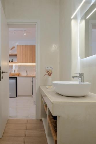 a white bathroom with a sink and a kitchen at Luaz Naxian living in Naxos Chora