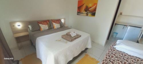 a bedroom with a bed with towels on it at AYRE GOSTOSO POUSADA in São Miguel do Gostoso