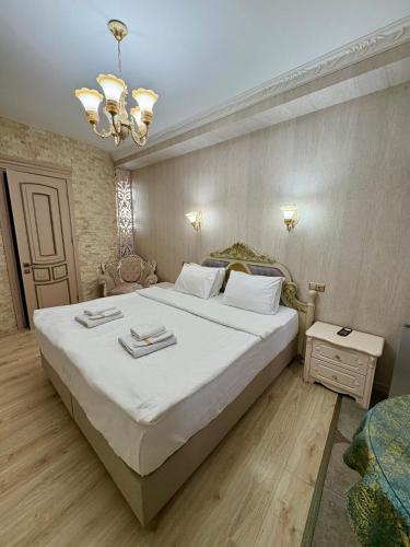a bedroom with a large bed and a chandelier at 34 Silver Rooms in Tbilisi City