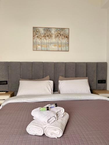 a bed with two towels sitting on top of it at Qeparo Antonio Rooms in Qeparo