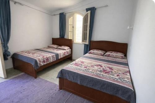 a bedroom with two beds and a window at Beach Family Villa - Private Pool - Sea view - Up to 14 guests- only 40 Meters to the Beach! in Alexandria