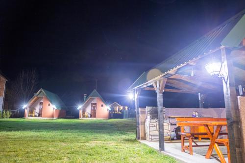 a picnic table in front of a house at night at Rest&peace homes in Mojkovac