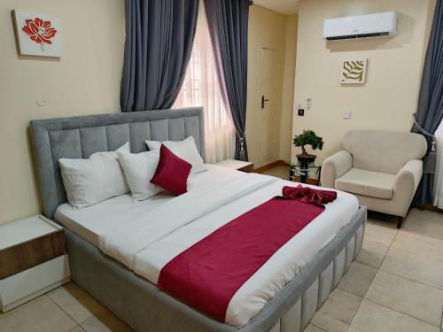 a bedroom with a large bed and a chair at Captain Residency Hotel in Lagos