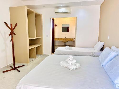 a room with two beds with towels on them at 4 Ventos House in São Miguel do Gostoso