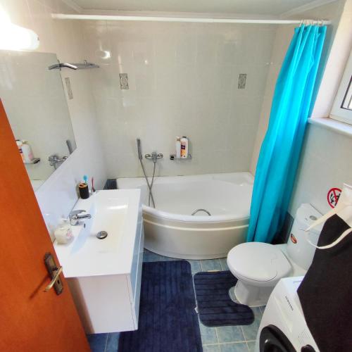 a bathroom with a tub and a toilet and a sink at Nature House Vlatos in Vlátos