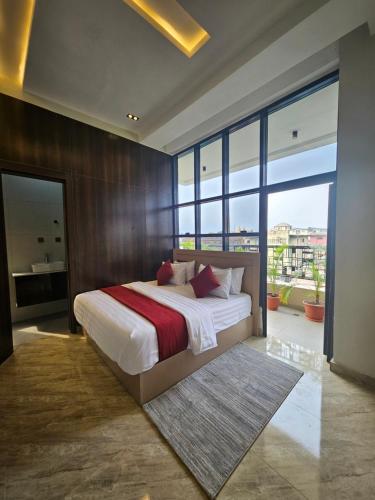 a bedroom with a large bed and large windows at Teestone Hotels and Apartment Ikeja in Lagos