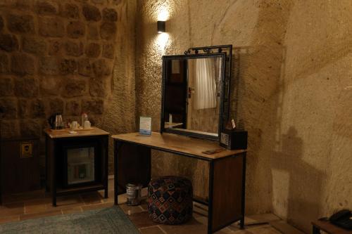 a bathroom with a mirror on a wooden counter at Cappadocia Vita Cave Hotel in Ürgüp