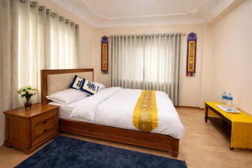 a bedroom with a large bed and a table at Monastery View Homestay in Kathmandu