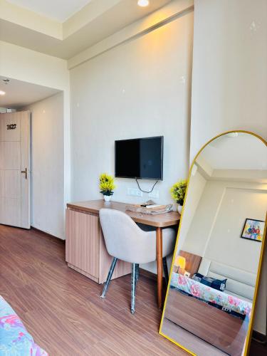 a hotel room with a desk and a mirror at Luxury stays in Greater Noida