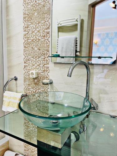 a glass sink in a bathroom with a mirror at Villa Diamond in Chişinău