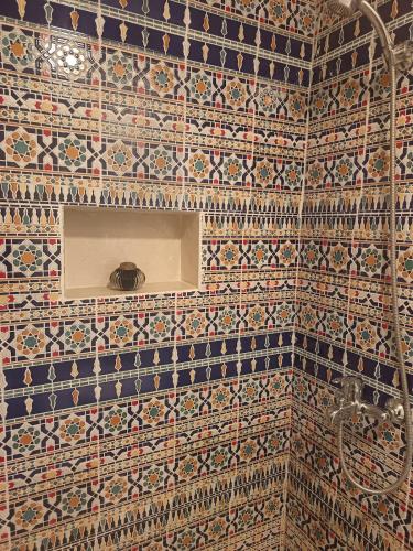 a bathroom with a tile wall with a shower at RiadTiznitSouss Votre oasis privée à Tiznit in Tiznit