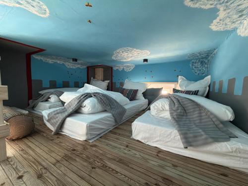 a bedroom with two beds in a blue room at Stadtpalais Belle Etage - historische Villa nahe Theater und Soletherme in Bad Elster