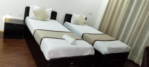 two twin beds in a hotel room at Hotel DR Retreat in Pakhyong