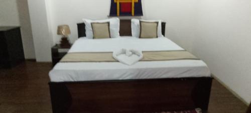 a bedroom with a bed with a heart pillow on it at Hotel DR Retreat in Pakhyong