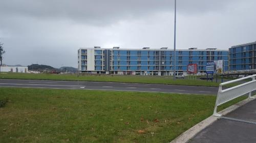 un banco blanco al lado de una carretera con un edificio en Apartamento Vista Deslumbrante en Ponta Delgada