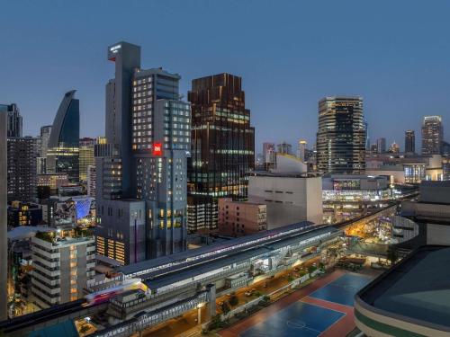a view of a city at night with trains at ibis Bangkok Siam in Bangkok