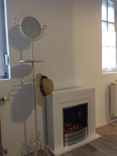 a living room with a fireplace and a mirror at Viktória Inn Tihany in Tihany